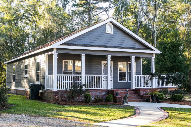 Gray modular cottage home with brick steps and porch